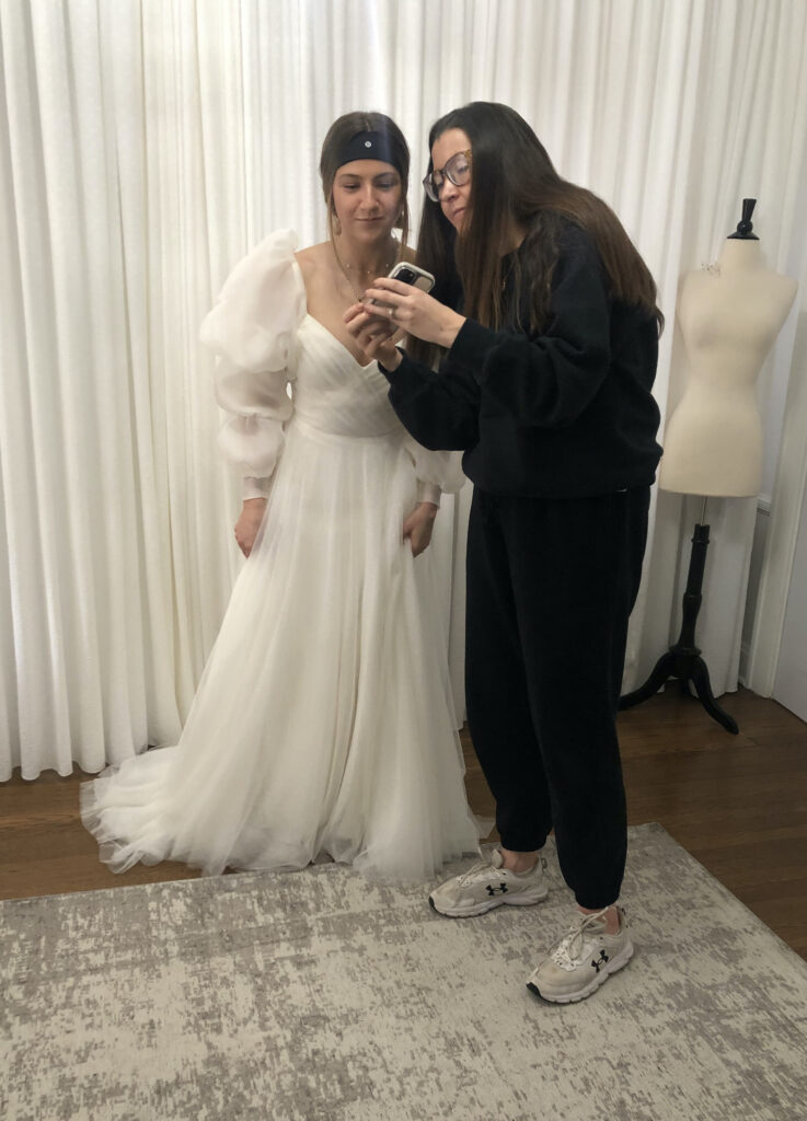 bride and sister admiring gown at pick up fitting