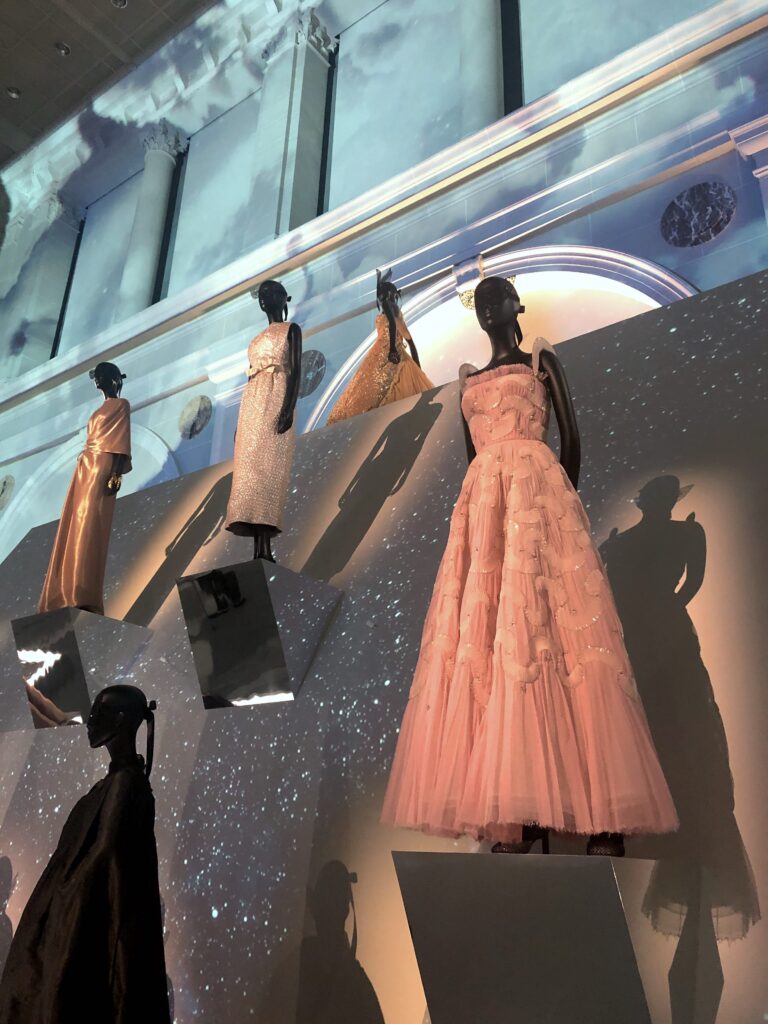 Beautiful Dior gowns in exhibit with glittery cloud projects